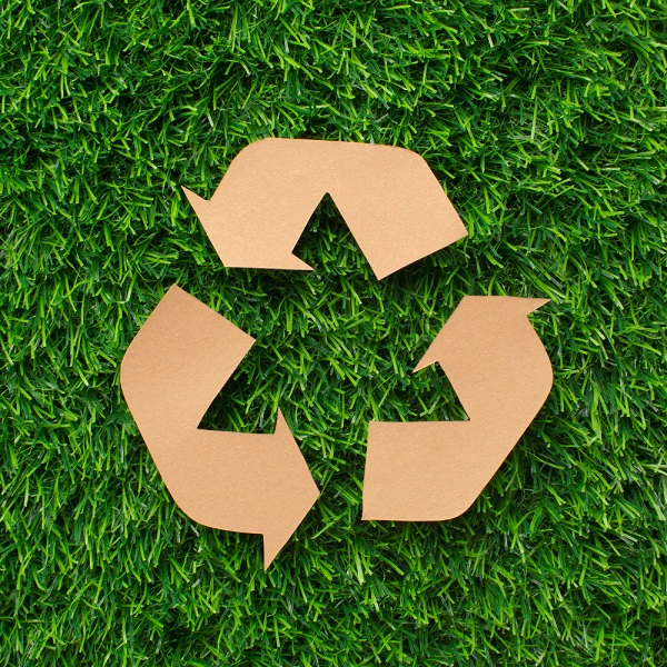 Cardboard recycle sign on grass